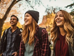 3 colllege aged people — one male and two females — in a park-like setting