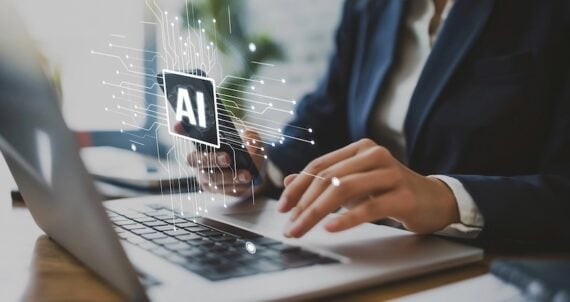 Human hands on a laptop keyboard with "AI" illustration above it