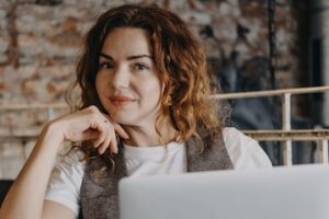 Photo of a female in a coffee-shop setting holding a laptop