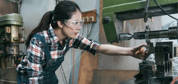 Female factory worker operating a machine Female factory worker operating a machine