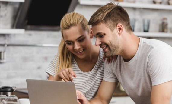A male and female shopping on a laptop computer